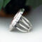 left side view, large oval wild horse magnesite gemstone silver statement ring, bezel set with stamped cutout wire accent